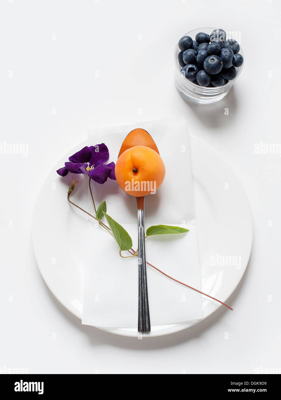 Still life with apricot and blueberries in glass tumbler Stock Photo