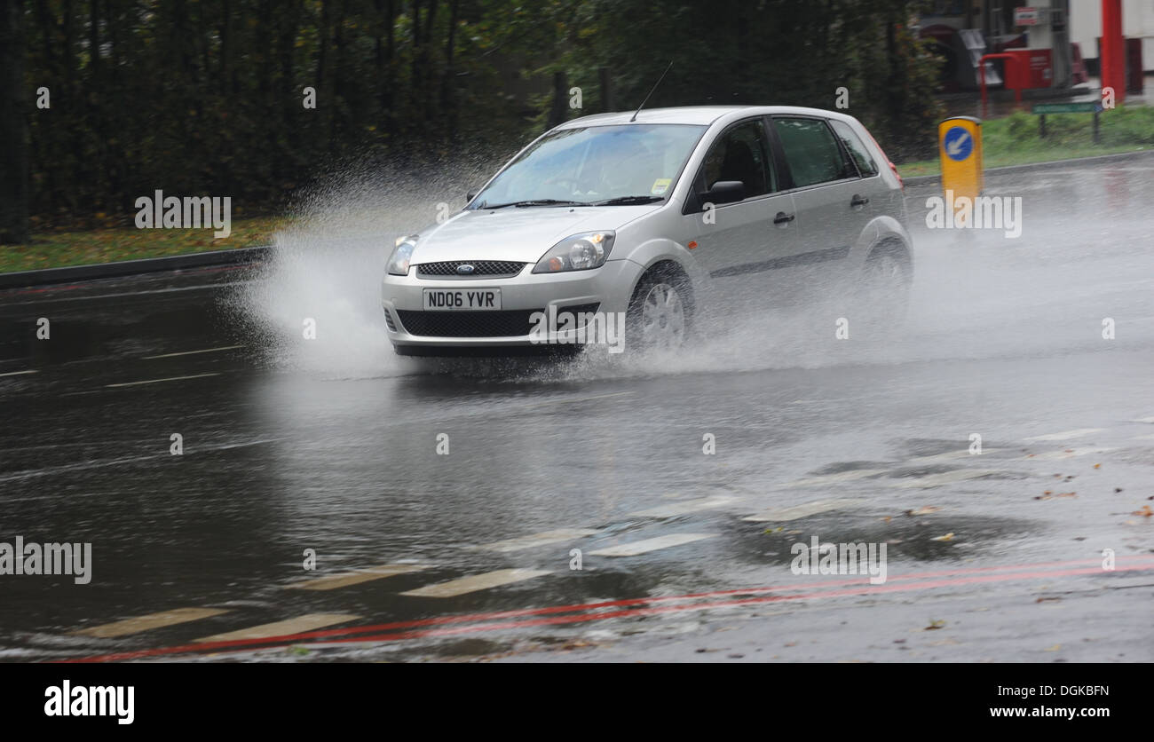A CAR TRAVELLING THROUGH HEAVY RAIN WATER SPRAY ON A PUBLIC ROAD RE