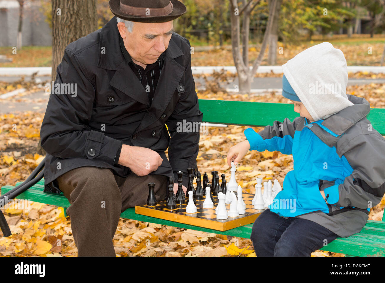 Дед с внуком играют в шашки. Деде шахматы в парке. Люди играют в шахматы на улице. Старики играют в шахматы в парке. Дети осень шахматы.
