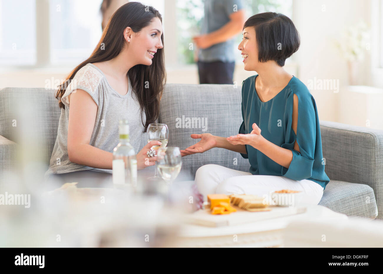 Two friends sitting on sofa and talking Stock Photo