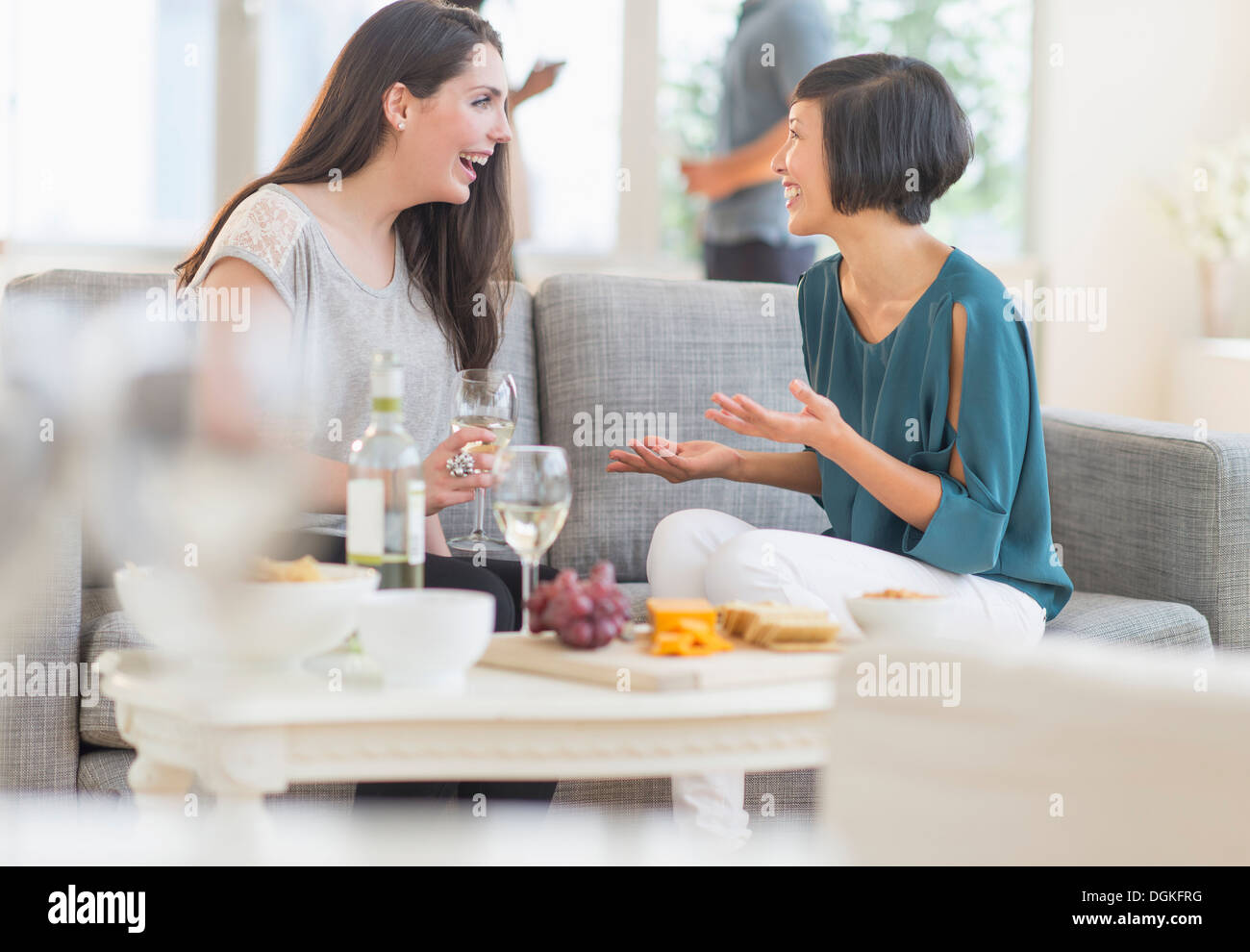 Two friends sitting on sofa and talking Stock Photo