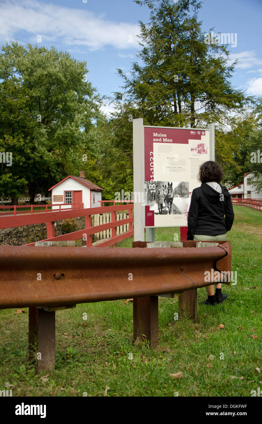 Young woman looking at information board at Lock. Delaware Canal Towpath, Pennsylvania. United states Stock Photo