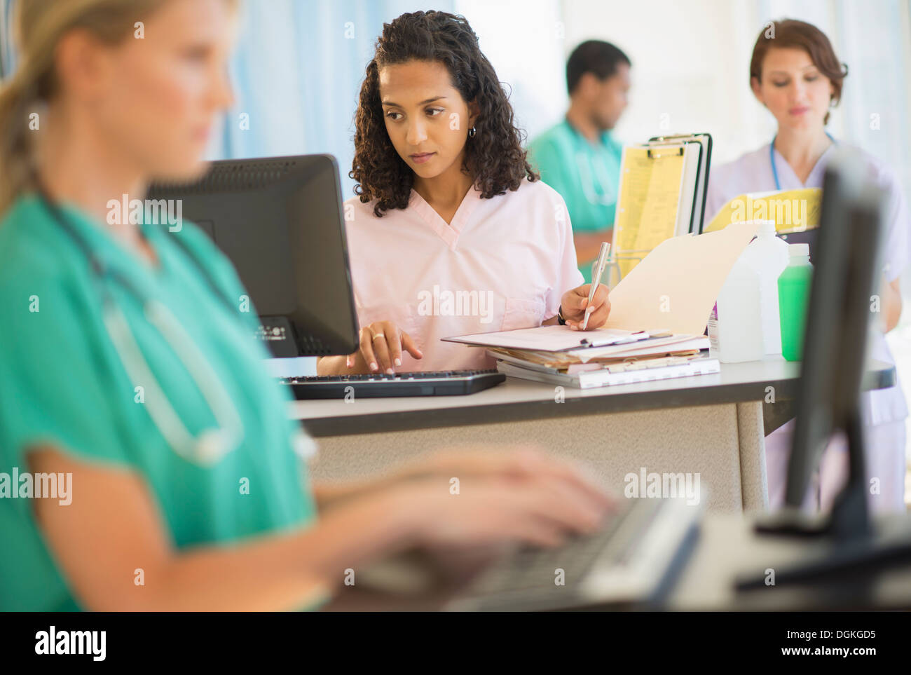 Doctors and nurses working at desks in hospital Stock Photo