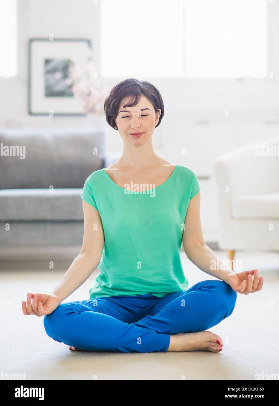 Young woman meditating at home Stock Photo