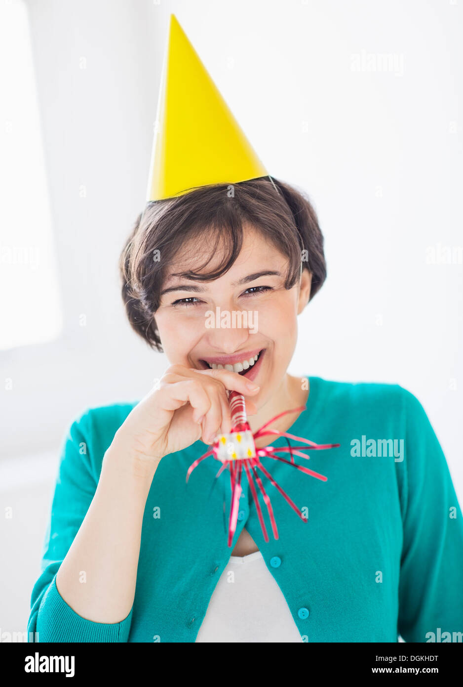 Young woman blowing party horn hi-res stock photography and images - Alamy