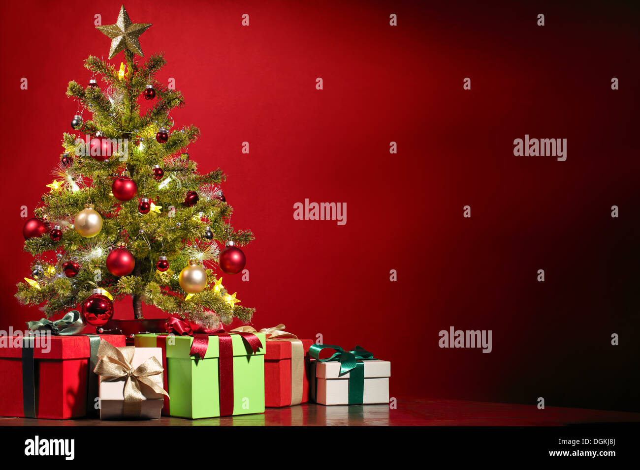 Christmas tree with gifts on red background. Stock Photo