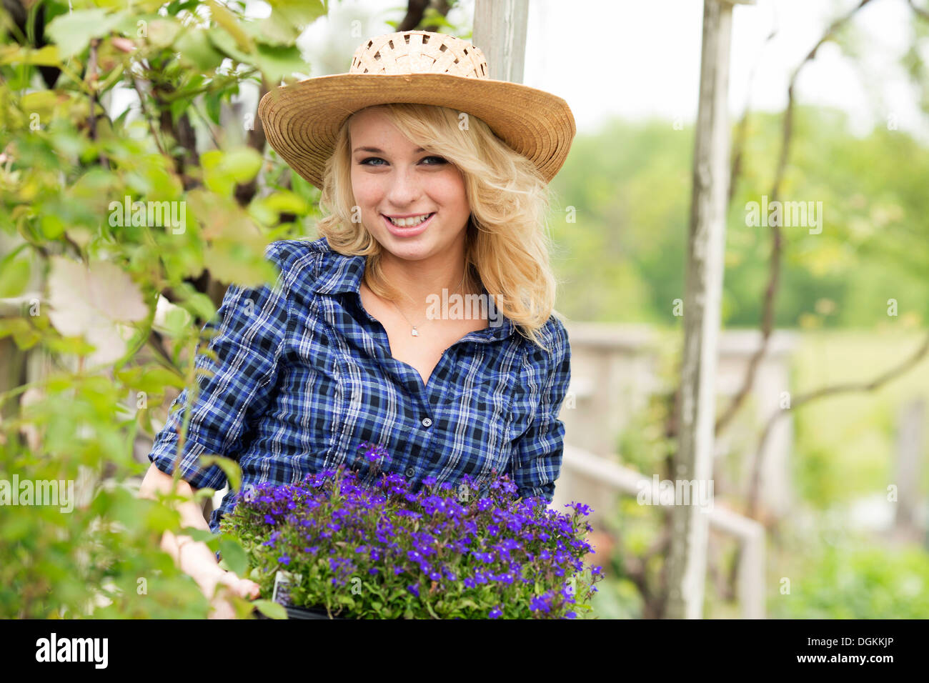 USA, New Jersey, Old Wick, Portrait of young woman holding potted flowers Stock Photo