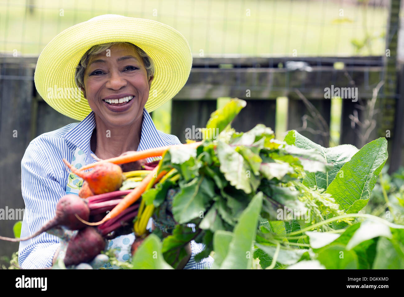 Portrait of senior woman holding carrots and beetroot Stock Photo
