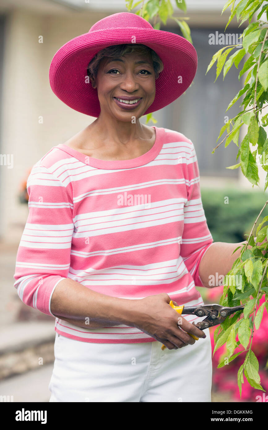 Portrait of senior woman pruning branch Stock Photo