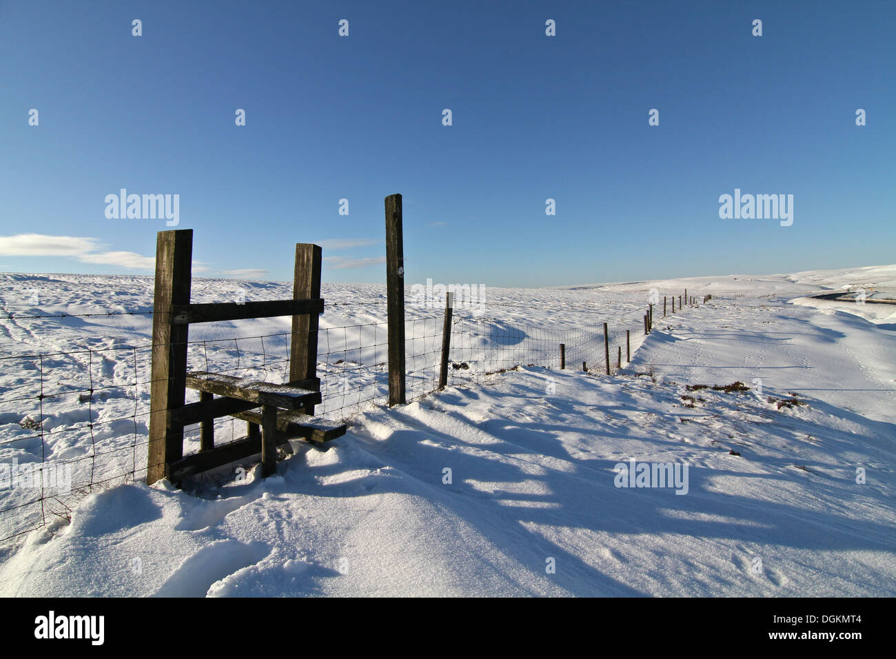 A stile across a fence high in the deeply snow covered Pennine Hills. Stock Photo