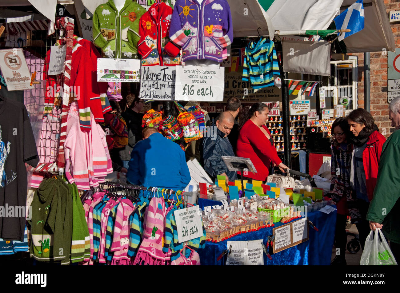 Childrens clothing for sale on market stall. Stock Photo
