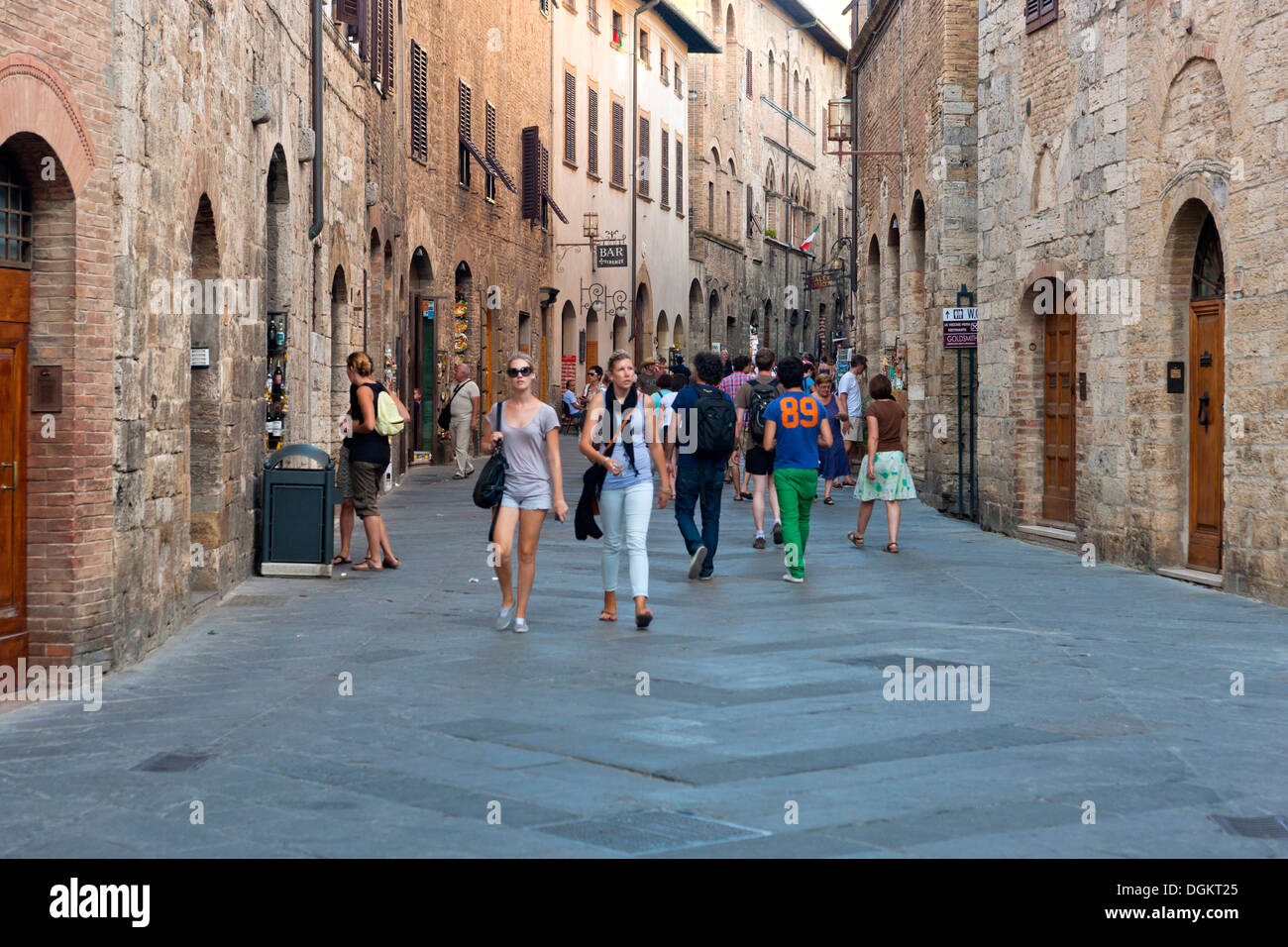 People walking along narrow street in San Gimignano. Stock Photo