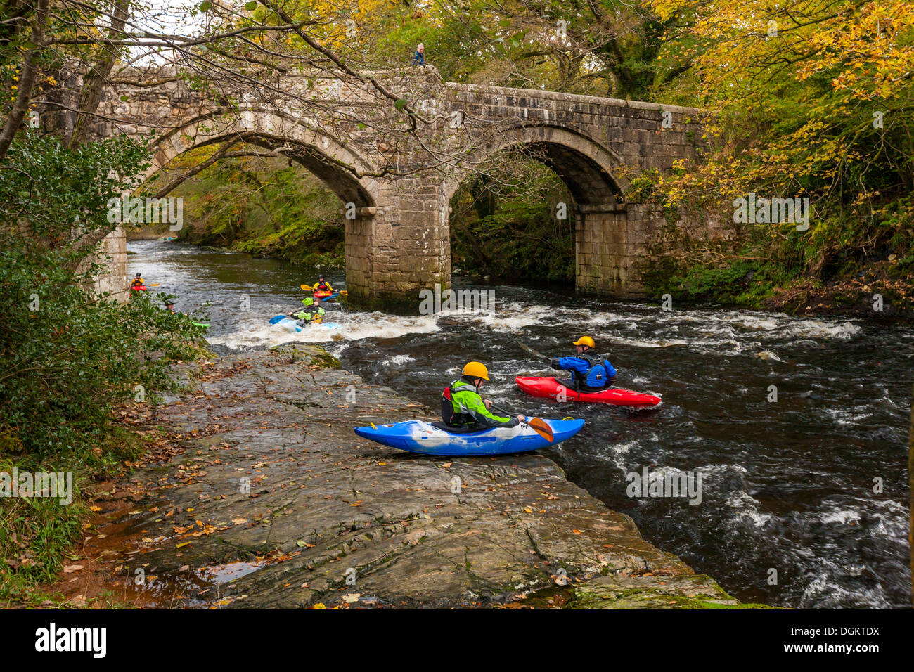 People kayaking on the river Dart near New Bridge in the Dartmoor National Park. Stock Photo