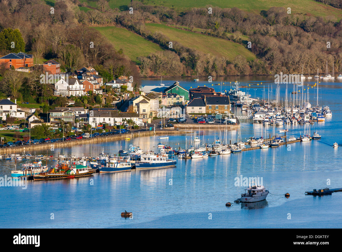 Boats moored on the river Dart with car ferry terminal in the background. Stock Photo