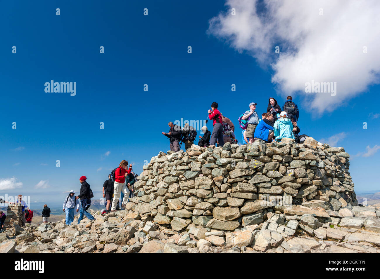 Tourists on the cairn at the summit of Scafell Pike. Stock Photo