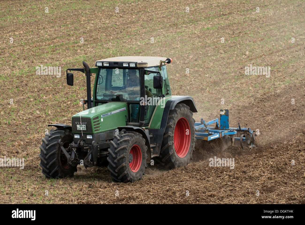 Tractor with a cultivator on farmland, PublicGround Stock Photo