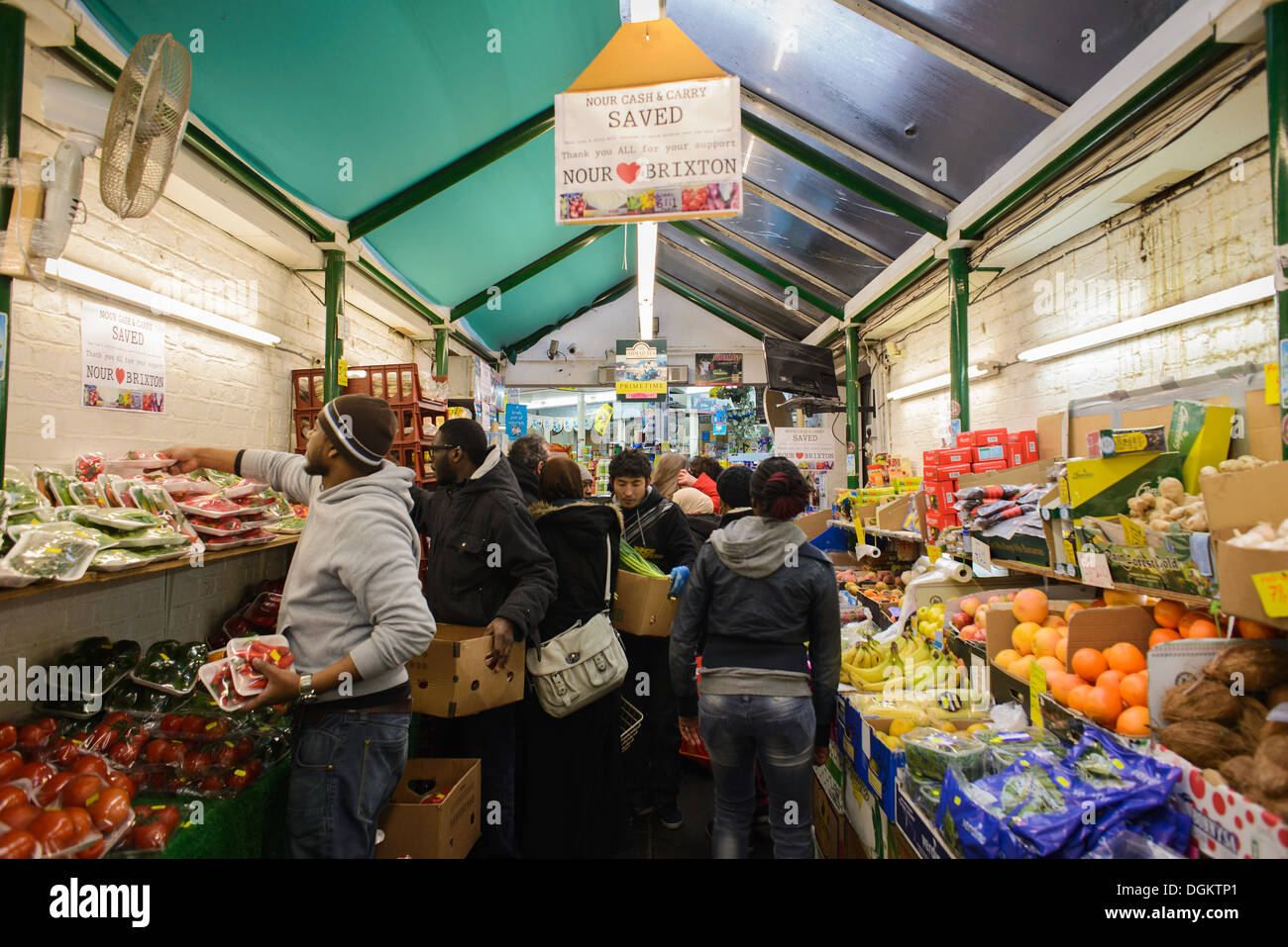 Customers shopping for produce in a crowded aisle at Nour Cash And Carry supermarket in Brixton Market. Stock Photo