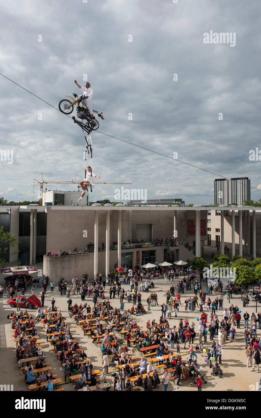 Museum Mile Festival, high-wire artist Falko Traber riding a motorbike on the tightrope, audience below, Bonn Stock Photo