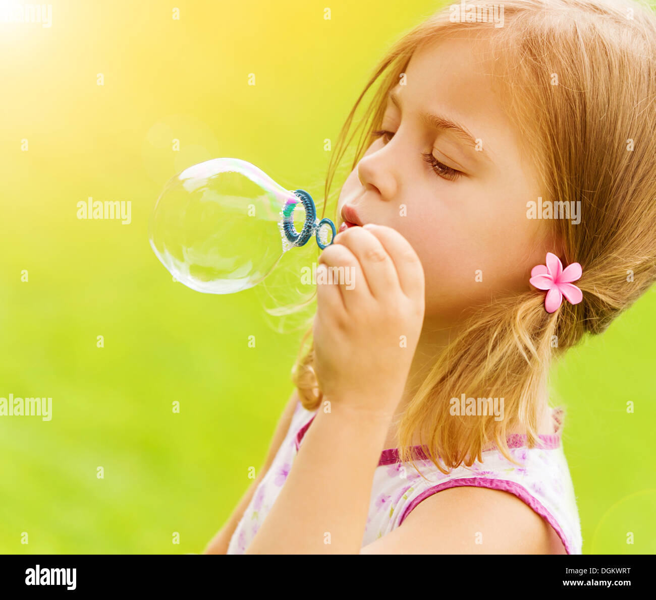 Sweet Little Girl Blowing Soap Bubbles In The Garden Summer Time