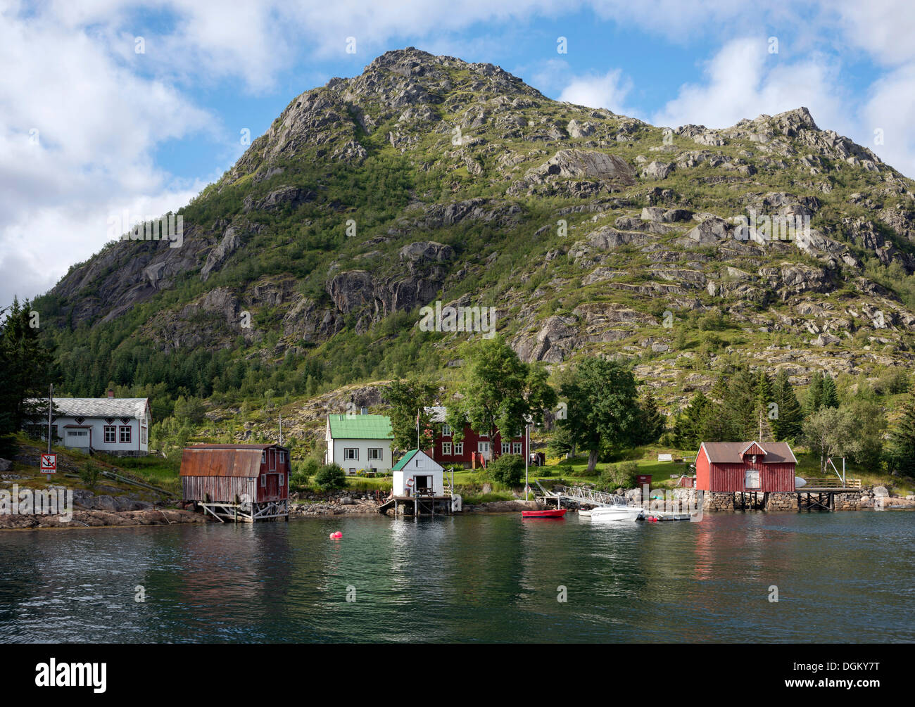 Colourful wooden houses on the shore with a jetty, rocky mountain at back, Svartsundet, Vestfjord, Lofoten, Nordland Stock Photo