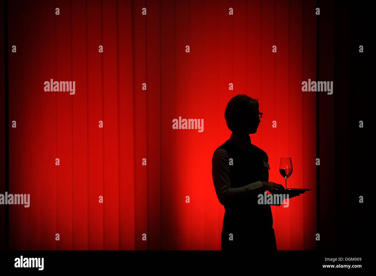 Silhouette of a waitress against a red wall Stock Photo