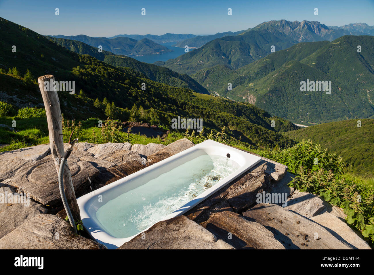 Alpe Nimi Mountain with a bathtub with a view towards the Alps, Valle Maggia, overlooking Lake Maggiore, Ticino, Switzerland Stock Photo