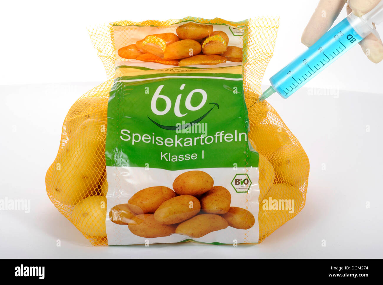 Syringe sticking in potatoes with BIO marking on the label, symbolic image, fraud with food labelled 'organic' Stock Photo