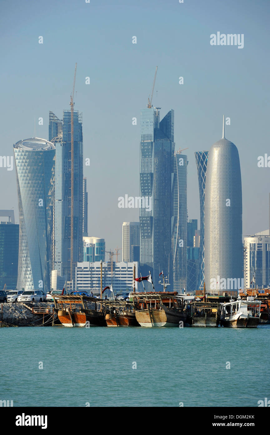 Tradition and modernity, dhow wooden cargo ships in front of the skyline of Doha, Qatar, Persian Gulf, Middle East, Asia Stock Photo