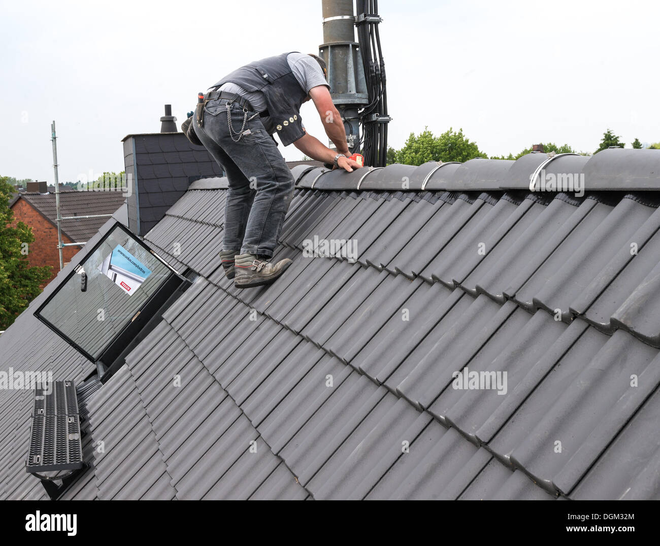 A roofer climbs without protection on a roof. Stock Photo