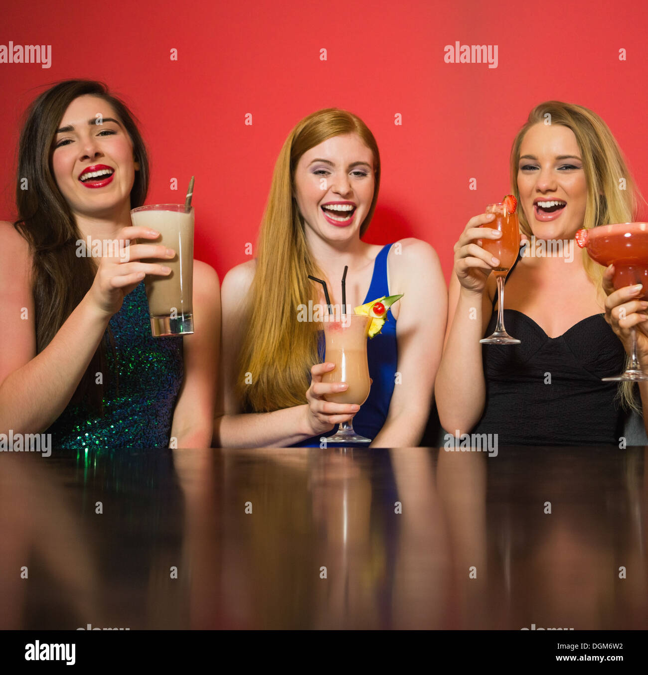 Laughing friends holding cocktails Stock Photo