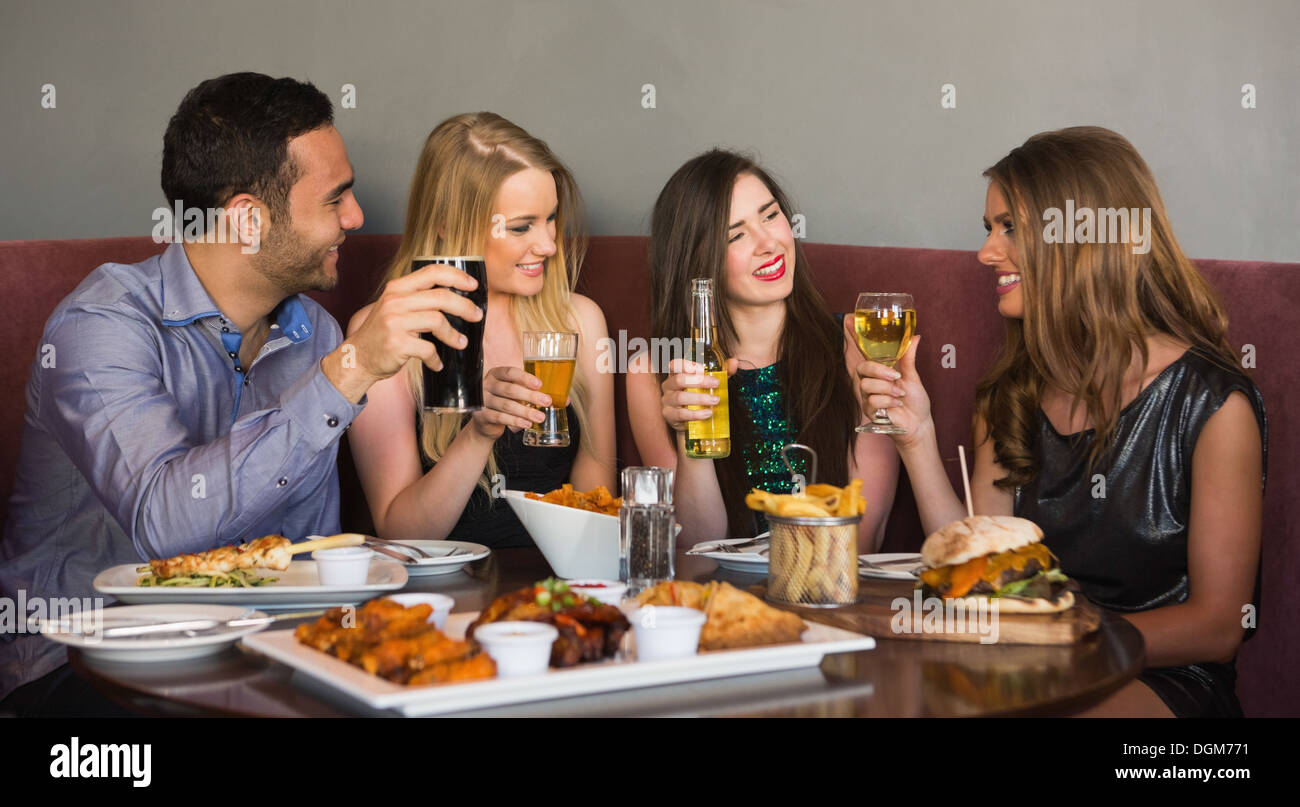 Happy friends sitting together having dinner Stock Photo