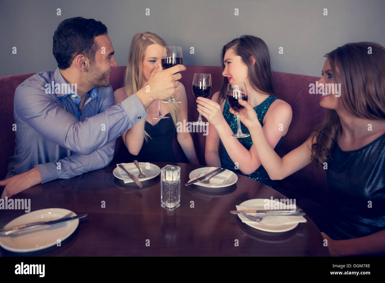 Smiling friends clinking wine glasses Stock Photo