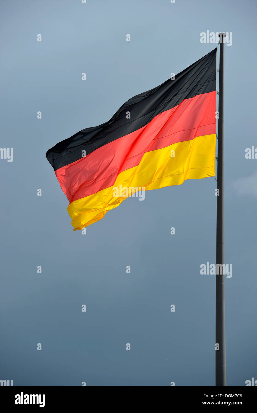 German flag against a dark sky, stormy atmosphere, Berlin, Berlin, Germany Stock Photo