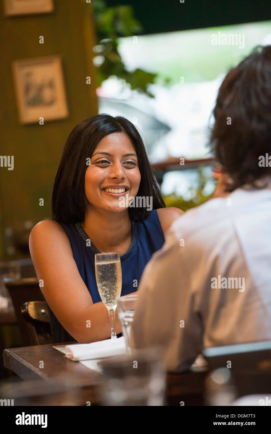 Business people. A couple seated at a table smiling at each other. Stock Photo