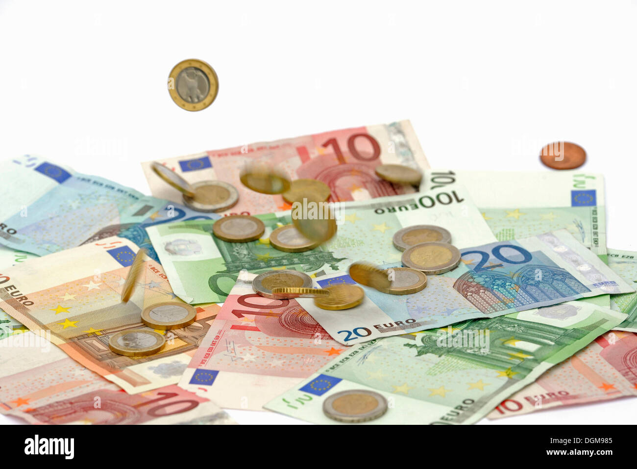 Euro coins falling on euro banknotes, raining money Stock Photo