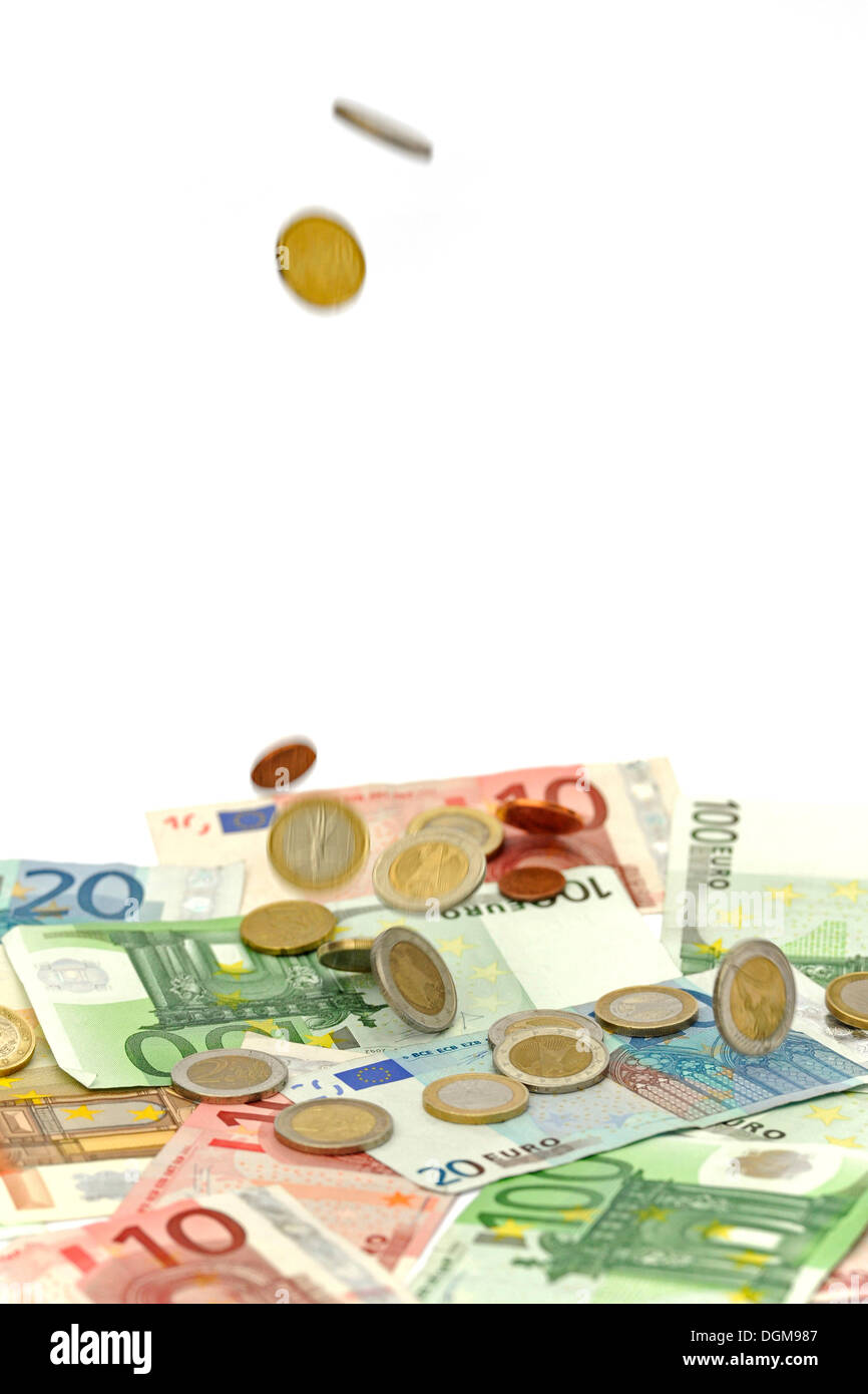 Euro coins falling on euro banknotes, raining money Stock Photo
