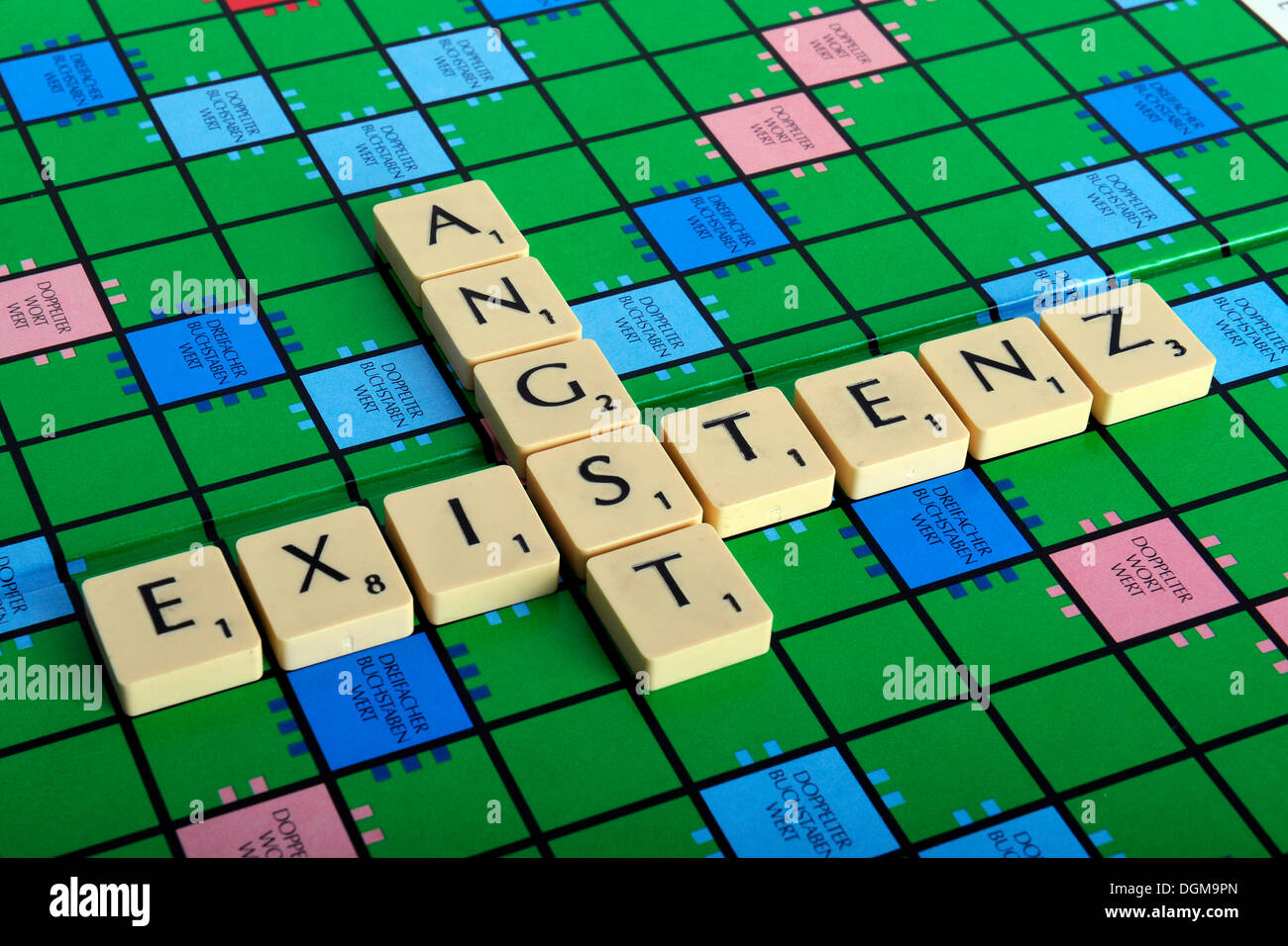 Scrabble letters forming the words Existenz and Angst, German for existential fear Stock Photo