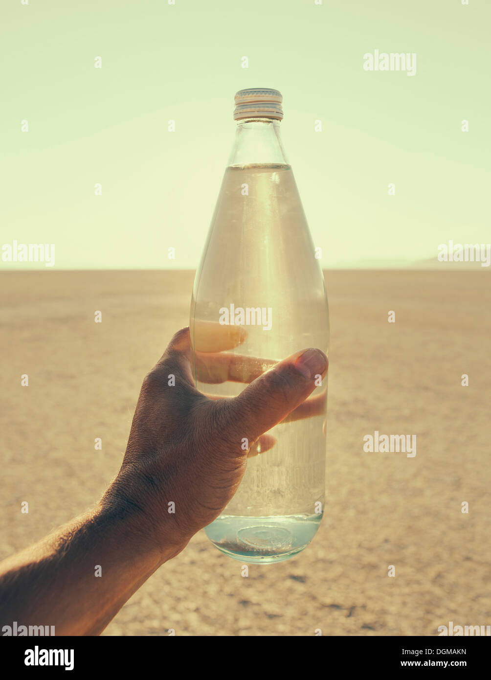 The landscape of the Black Rock Desert in Nevada. A man's hand holding a bottle of water. Filtered mineral water. Stock Photo