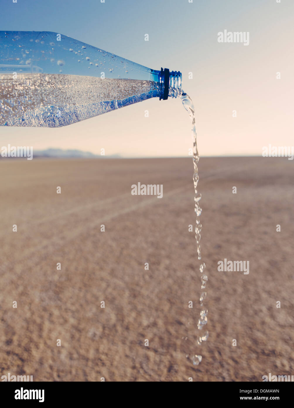 The landscape of the Black Rock Desert in Nevada. A bottle of water being poured out. Filtered mineral water. Stock Photo