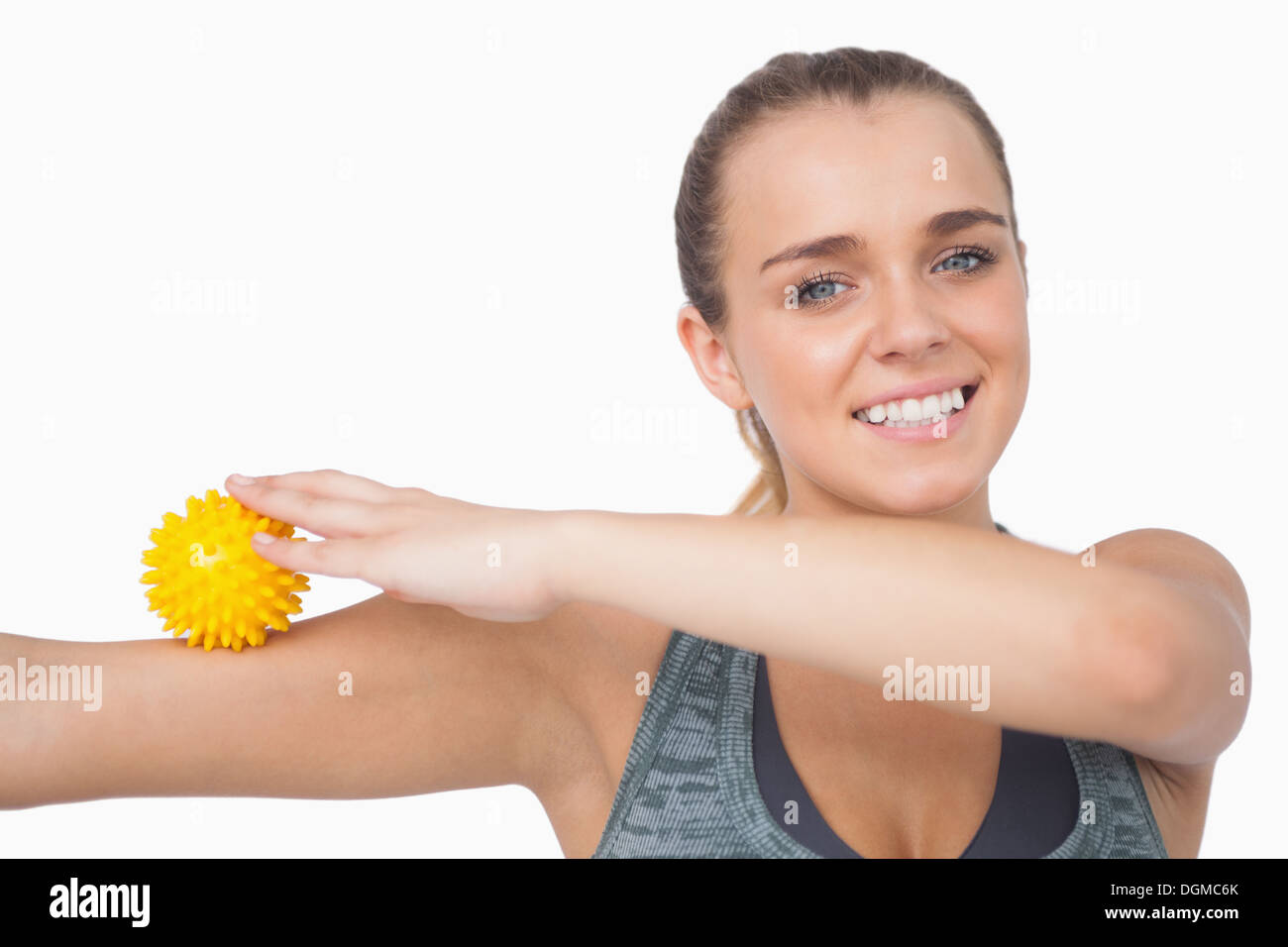 Cheerful young woman touching arm with massage ball Stock Photo Alamy