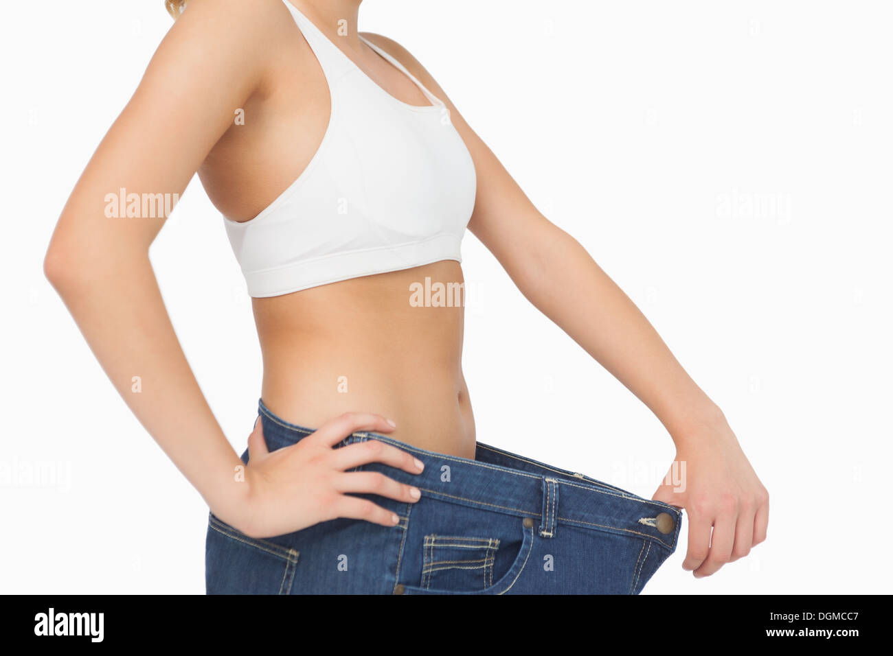 Mid section of slim young woman wearing too big jeans Stock Photo