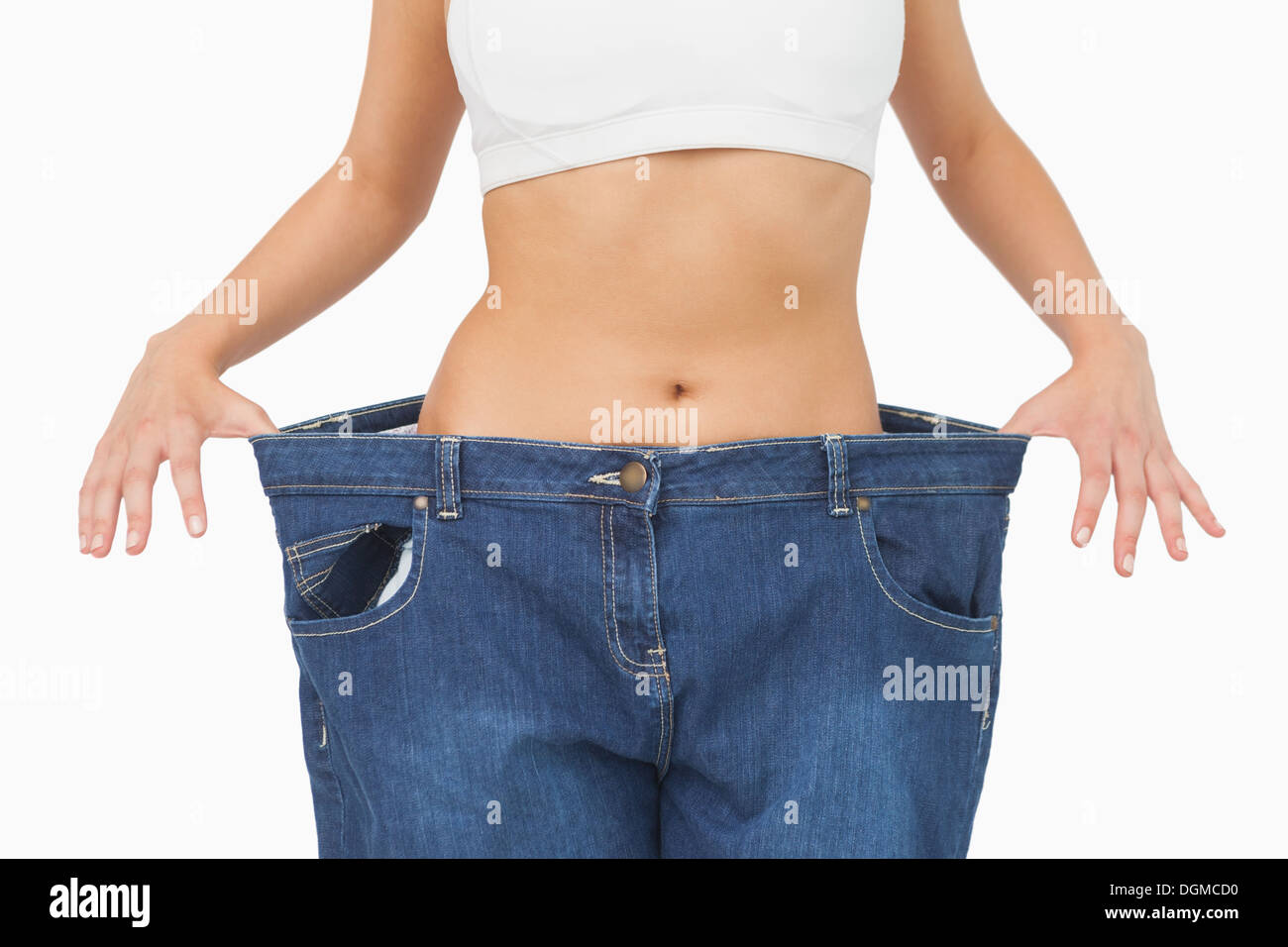 Mid section of young slim woman wearing too big jeans Stock Photo