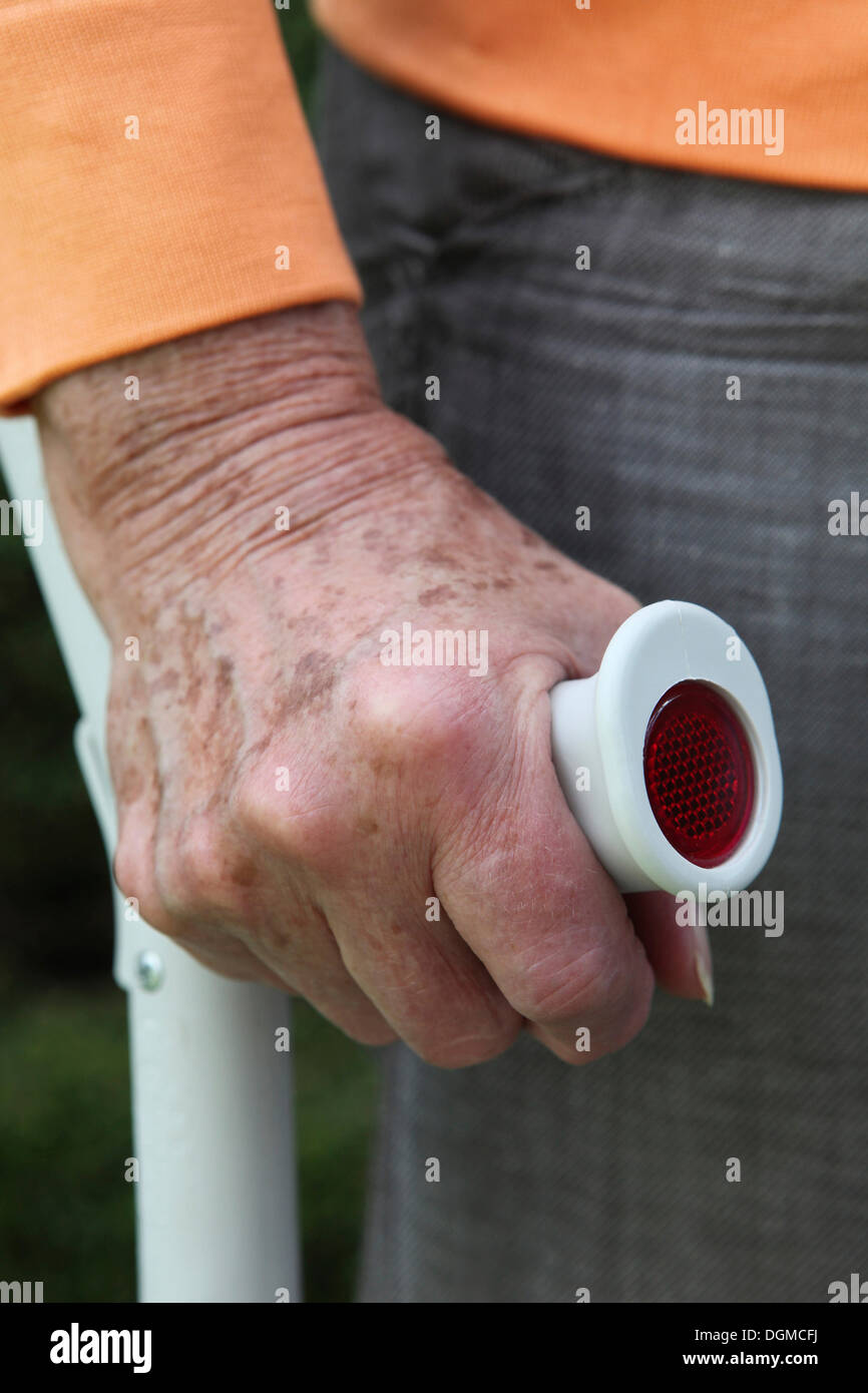 Elderly woman standing with a crutch in her hand Stock Photo
