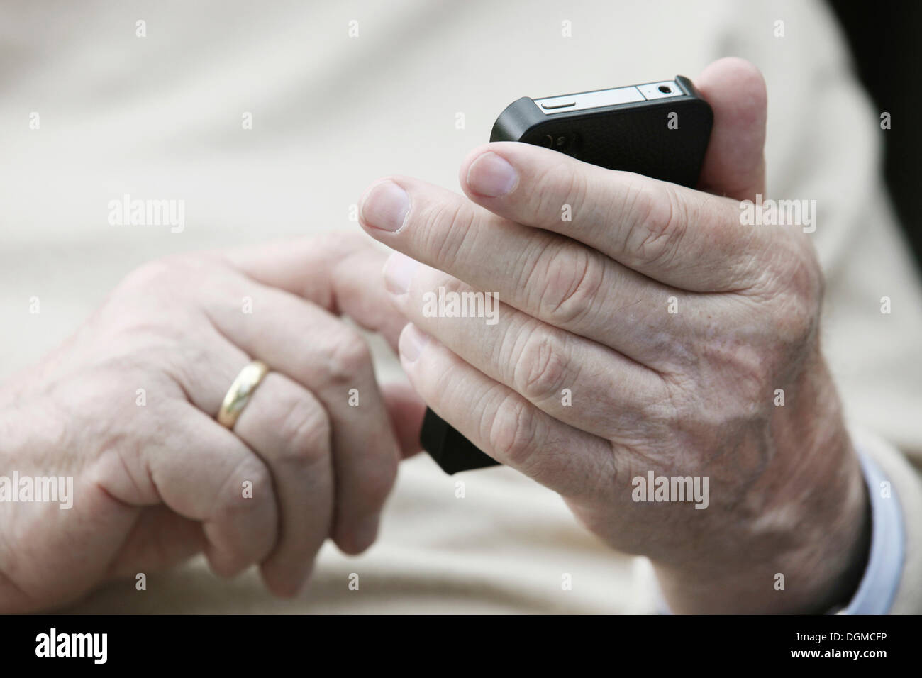 Senior holding a smartphone in his hands Stock Photo