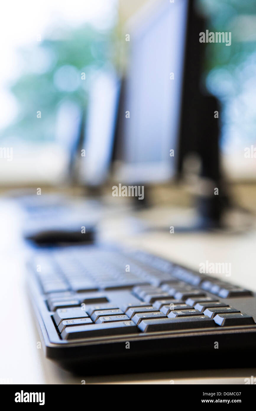 Computer monitors, keyboards and mouse in a training classroom Stock