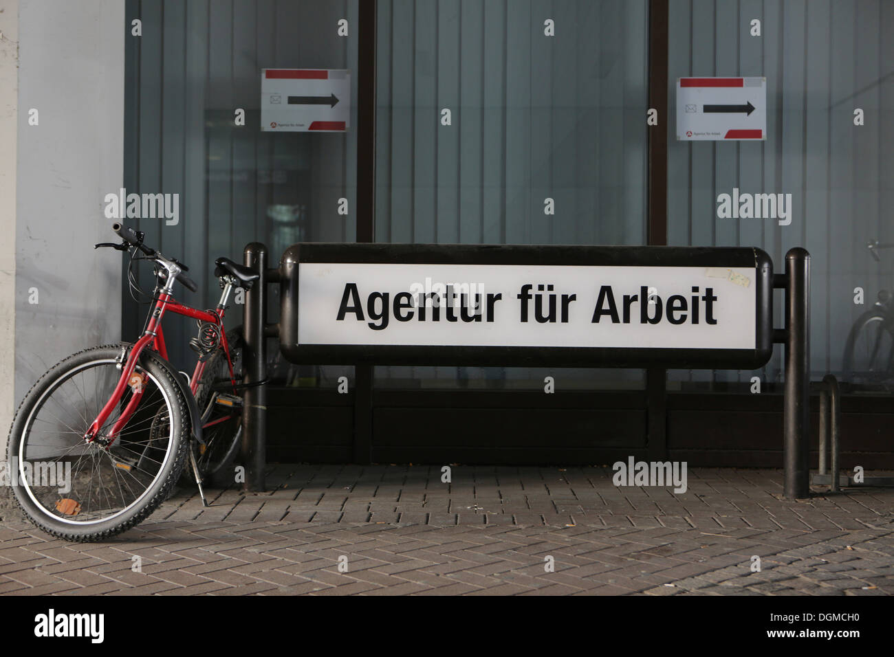 Bicycles parked beside the sign 'Agentur fuer Arbeit', German for Employment Agency, Cologne, Rhineland, North Rhine-Westphalia Stock Photo