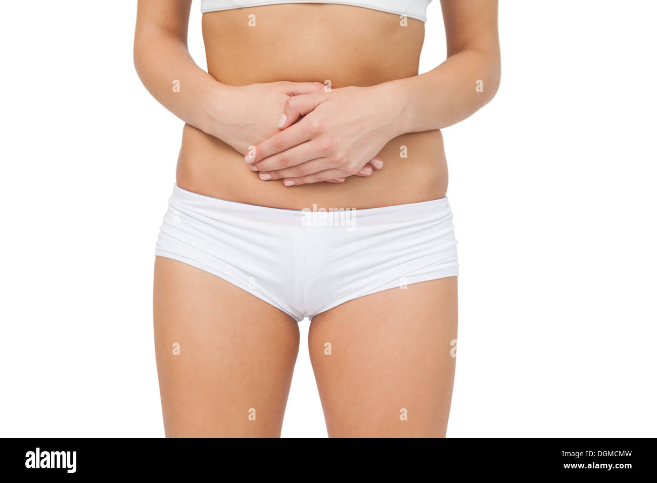 Mid section of woman touching her belly with her hands Stock Photo