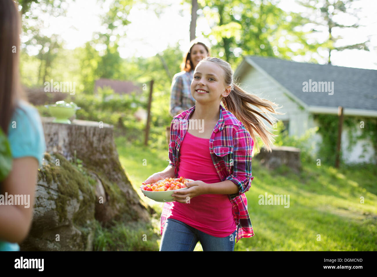 Organic farm. Summer party. Three girls running across the grass Stock
