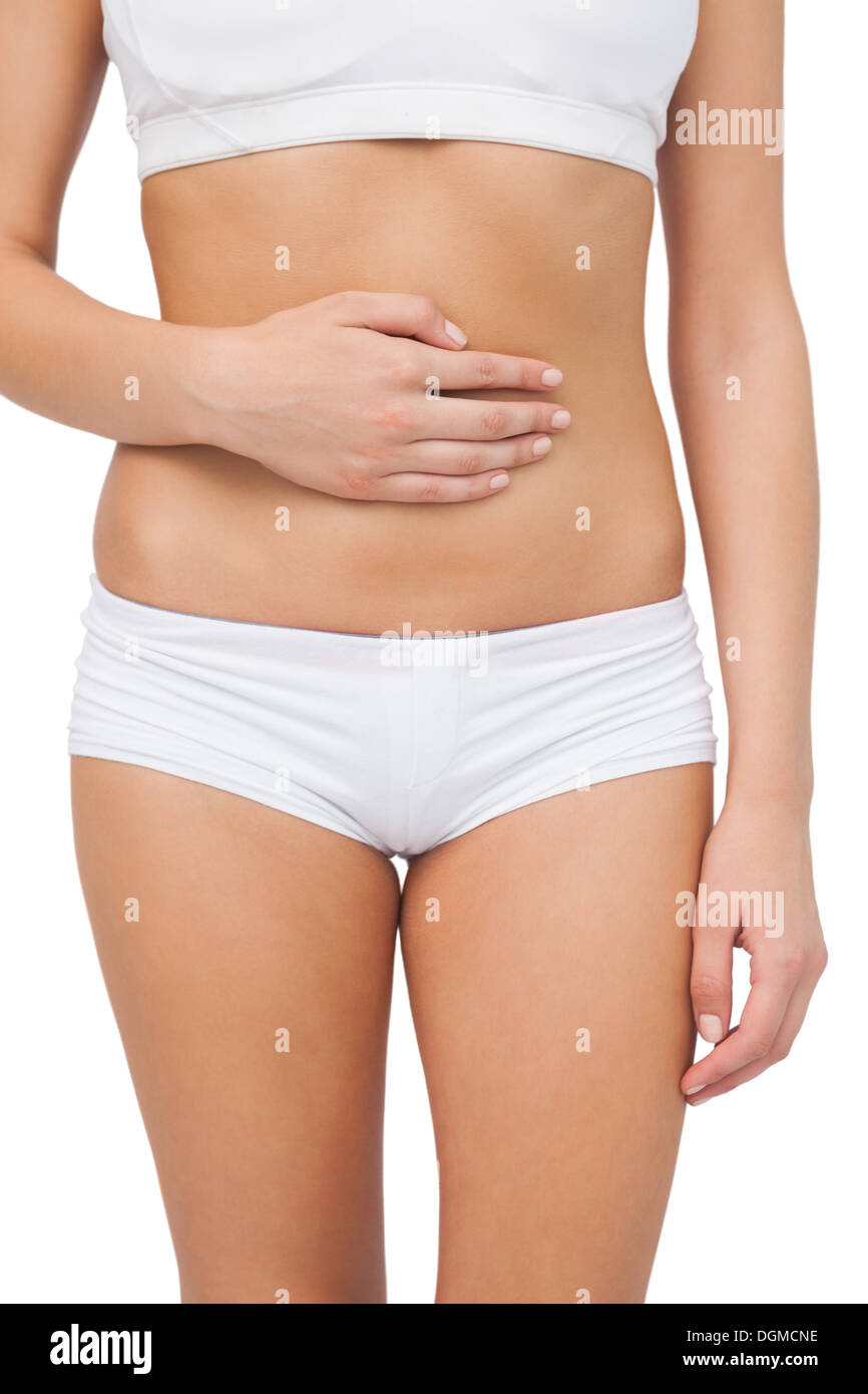Young slim woman touching her belly with one hand Stock Photo