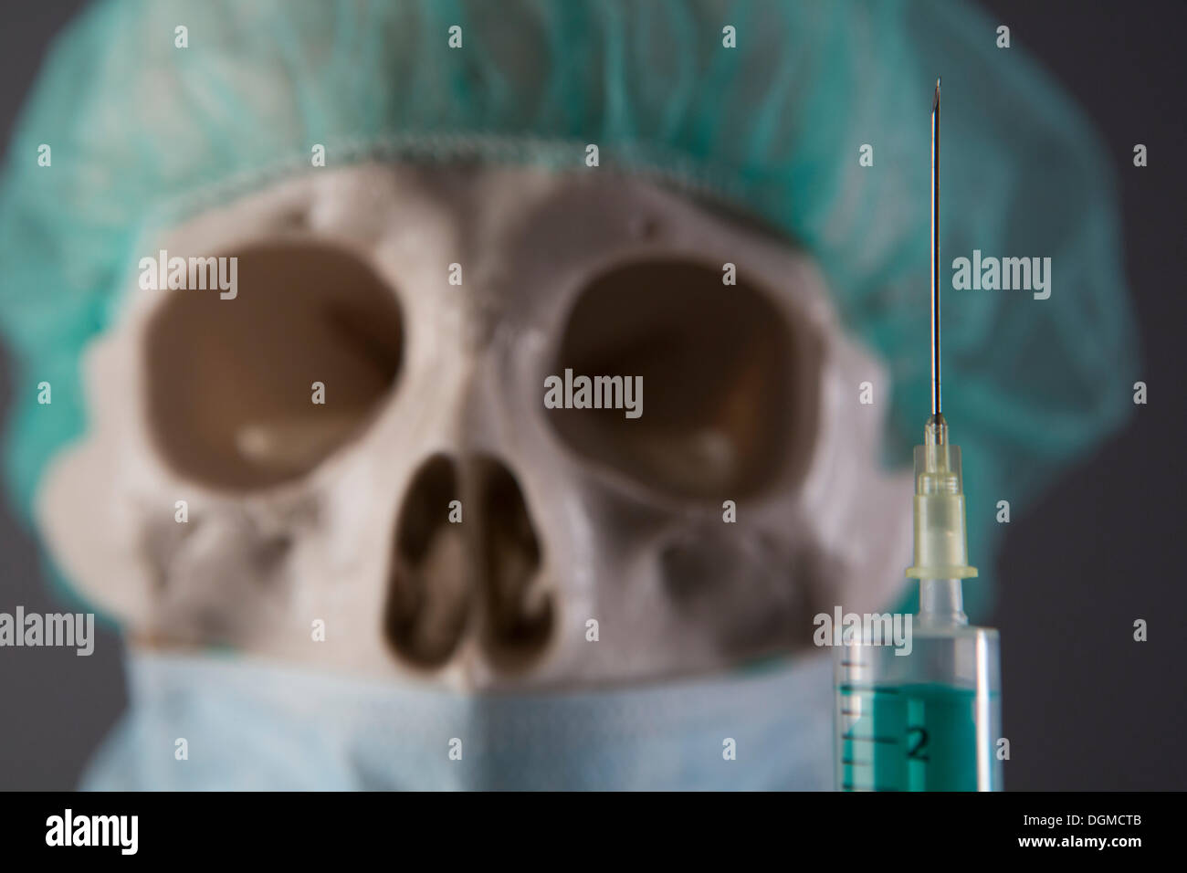 Skeleton dressed as a doctor with cap, surgical mask and syringe, Germany Stock Photo